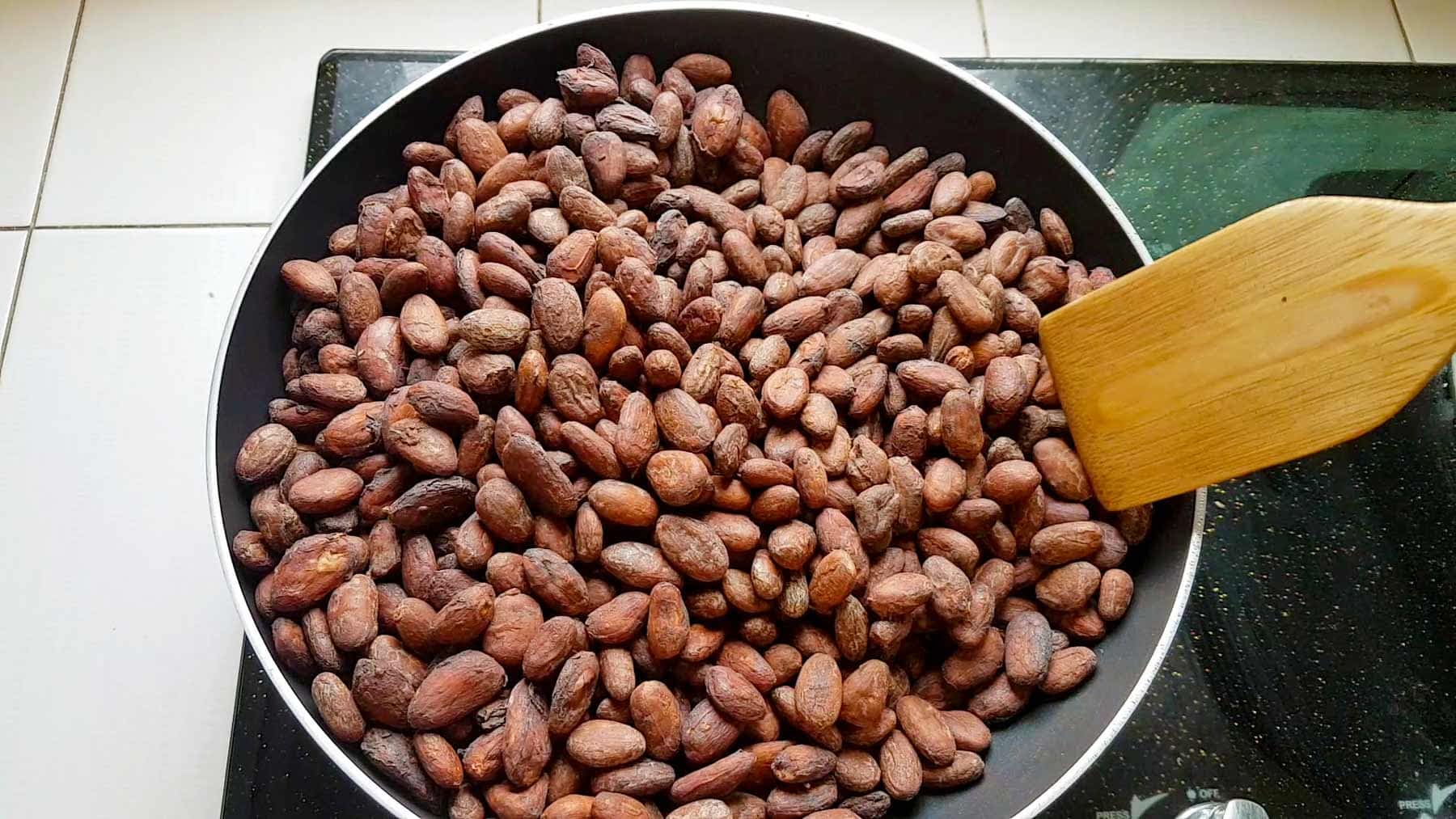 Roastin-Beans-at-Home Roasting cocoa beans in a pan on a stove.